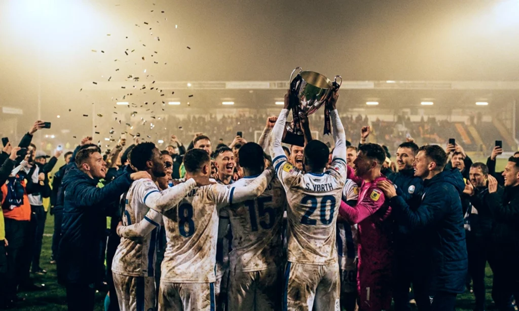 Футбольная команда празднует победу и трофей с 1xBet